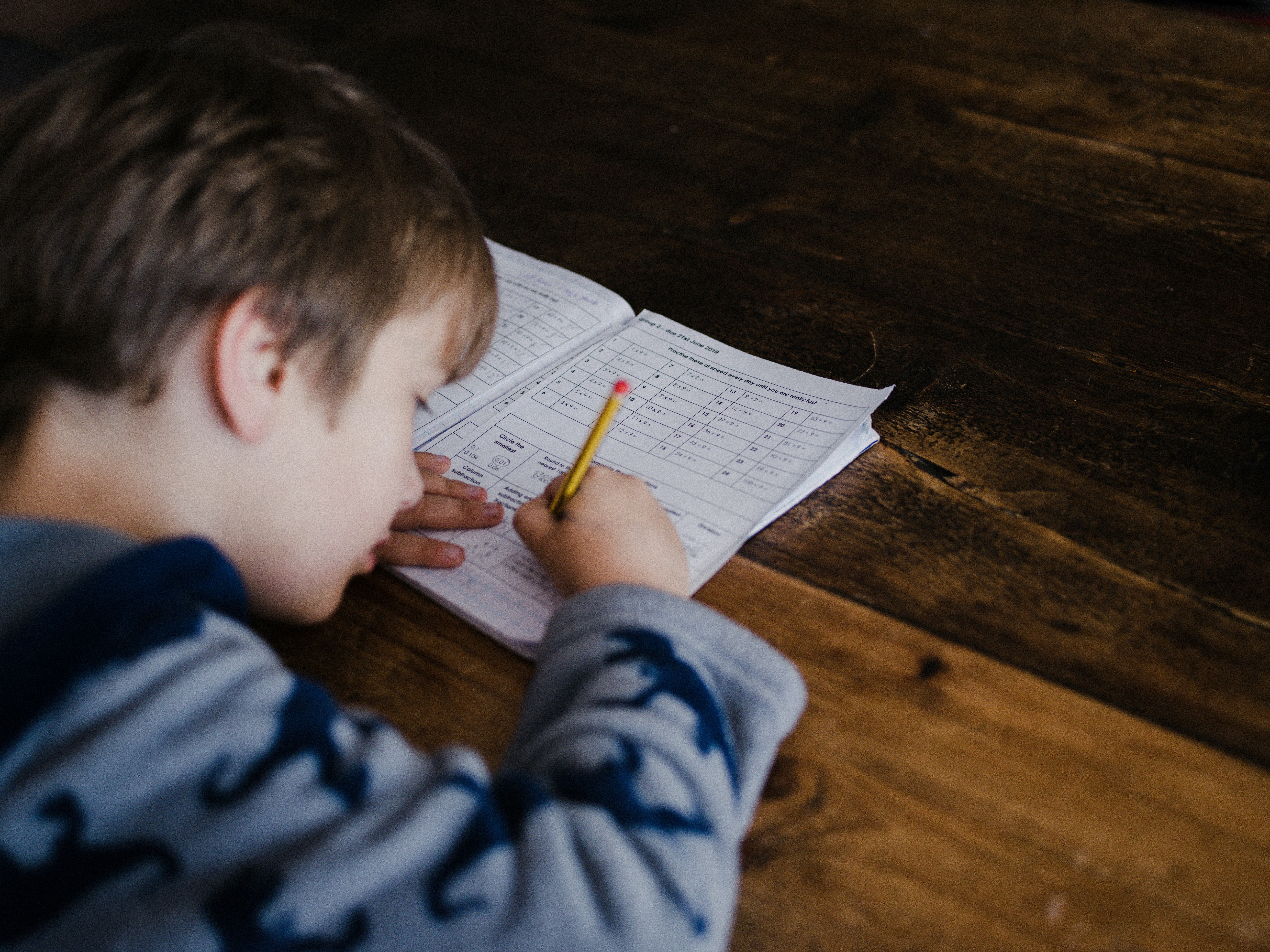 A young child writing in a workbook, representing focus and learning in an educational quiz setting.